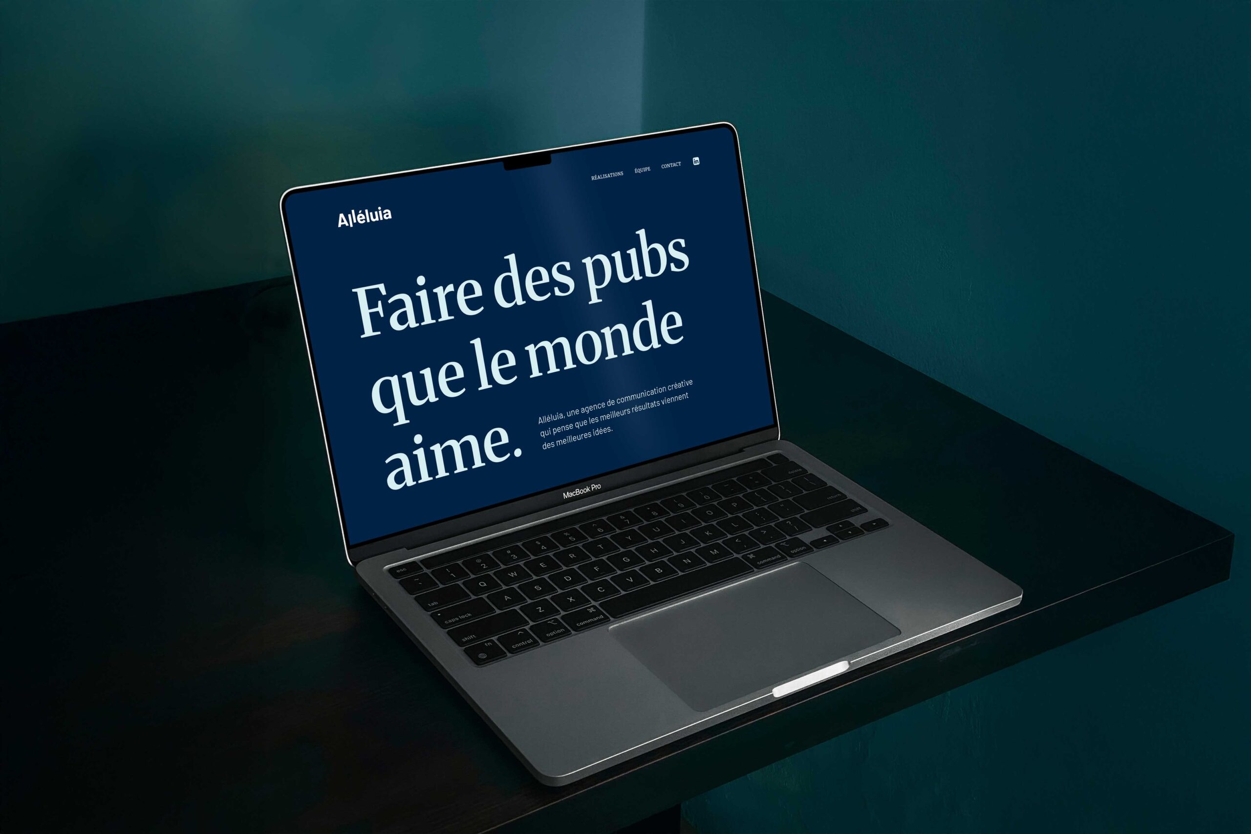 Ordinateur portable affichant le site d'Alléluia et son slogan « Faire des pubs que le monde aime »