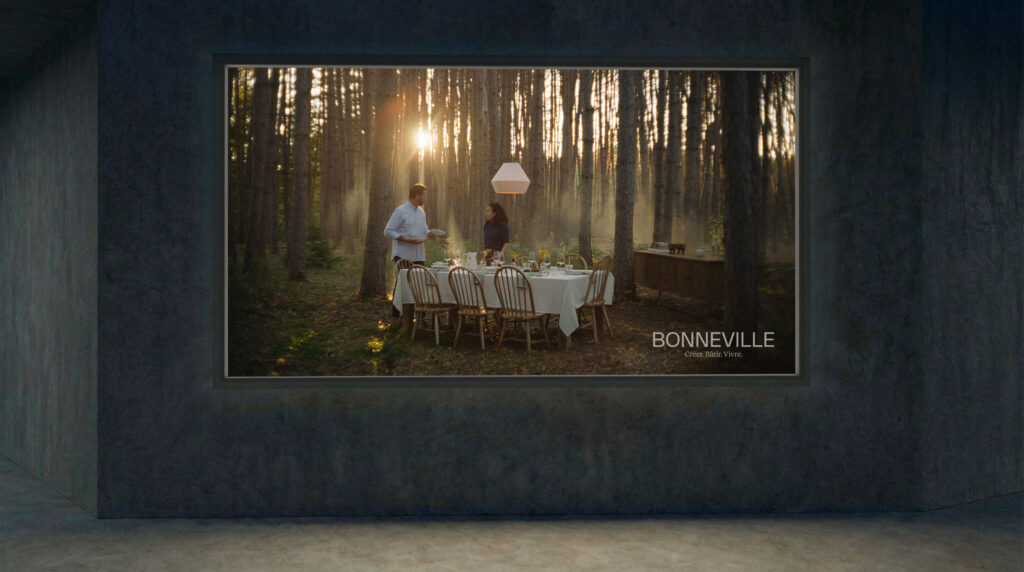 Mockup of a framed wall print showing a forest dinner scene with the 'Bonneville – Create. Build. Live.' tagline
