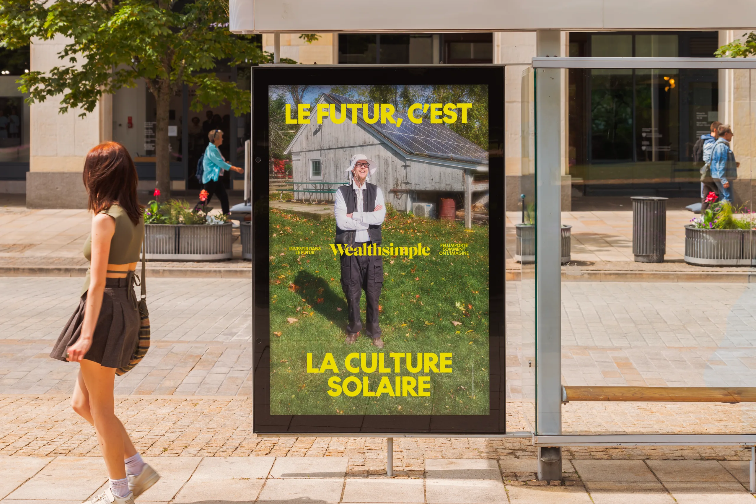 “Le futur, c'est la culture solaire” poster in a bus shelter, with a passer-by beside it