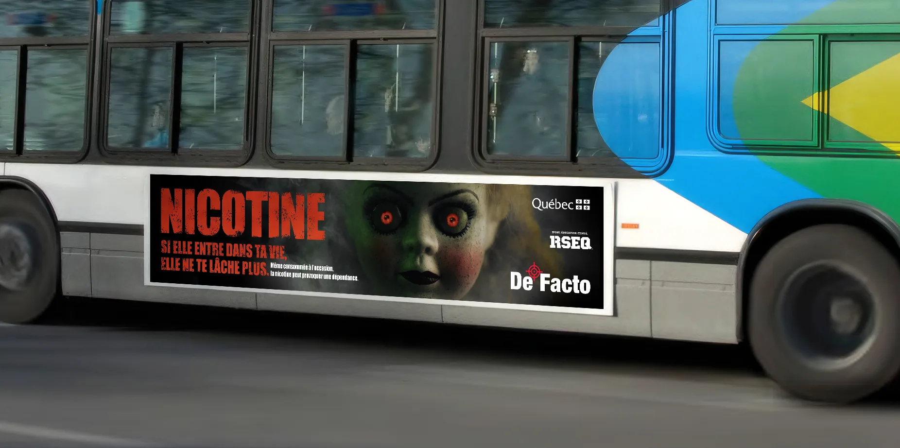 Flanc d’autobus avec la publicité « Nicotine, si elle entre dans ta vie, elle ne te lâche plus » et la poupée aux yeux rouges