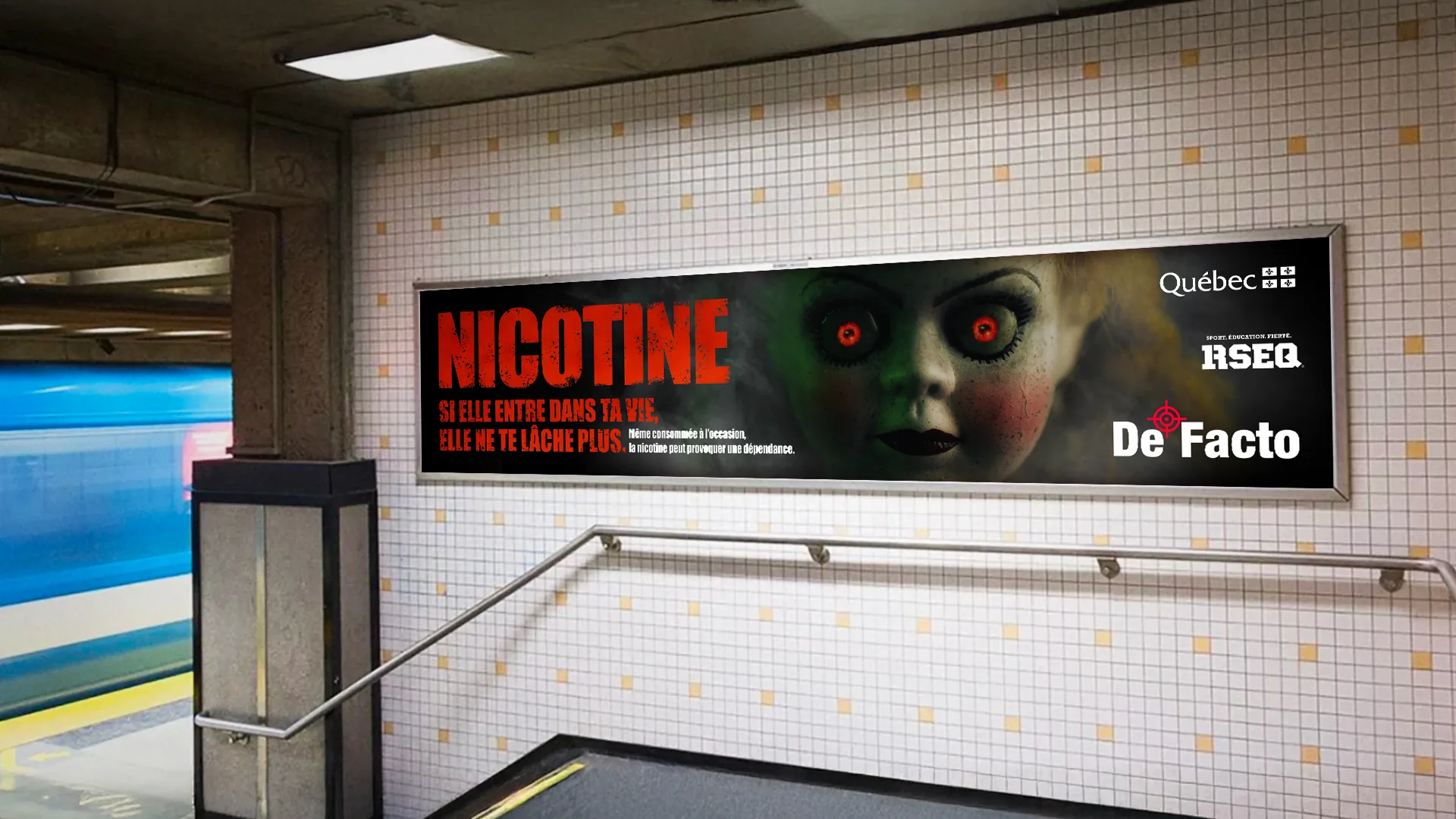 Grand panneau horizontal « Nicotine » dans l’escalier d’une station de métro, avec la poupée aux yeux rouges